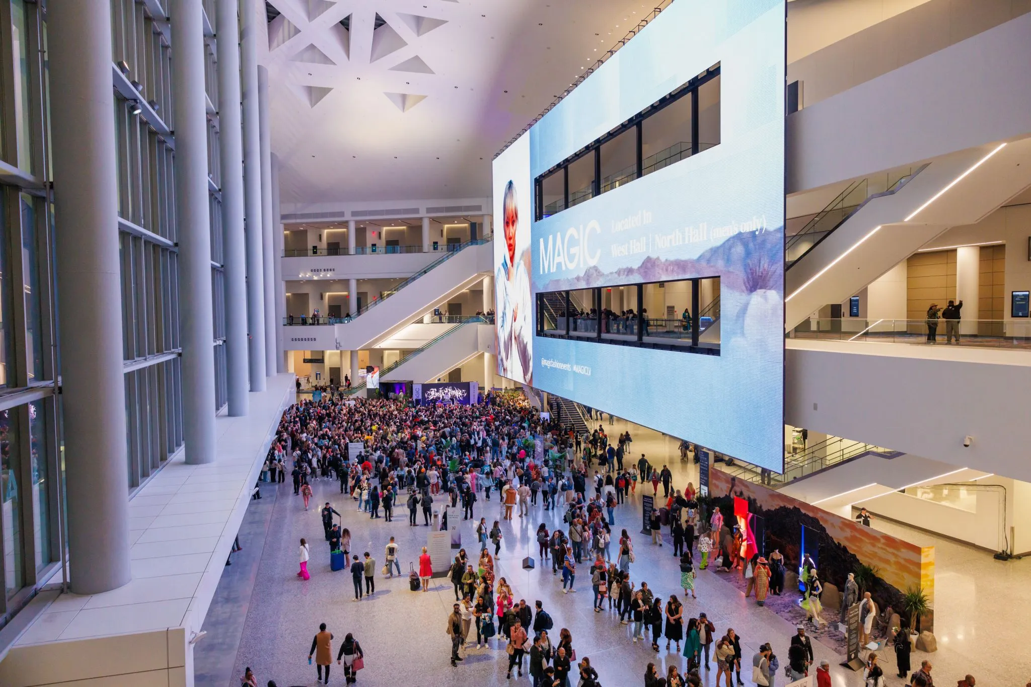 Busy entrance hall into the event with an LED structure showcasing branded video clips